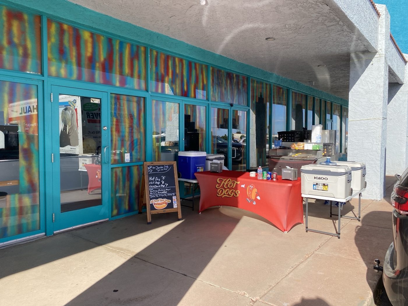 Desert Grub Co. hot dog cart set up outside a business